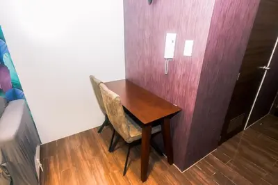 a wooden desk with a chair next to a wall at Air residence Snuggle in Style 1 BR condo Makati swim gym park surf 300 Mb in Manila