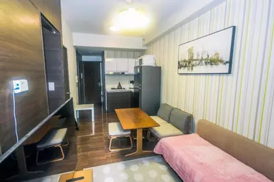 a room with a couch and a table and a kitchen at Urban Oasis Sleep in Style Makati Comfy Gym Swim Park 914 in Manila