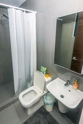 a bathroom with a white toilet and a sink at Urban Oasis Sleep in Style Makati Comfy Gym Swim Park 914 in Manila