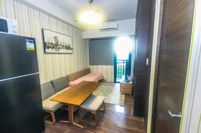 a dining room with a wooden table and chairs at Urban Oasis Sleep in Style Makati Comfy Gym Swim Park 914 in Manila