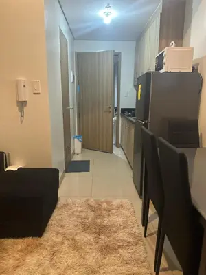 a kitchen with a refrigerator and a table and chairs at Jaja staycation in Manila