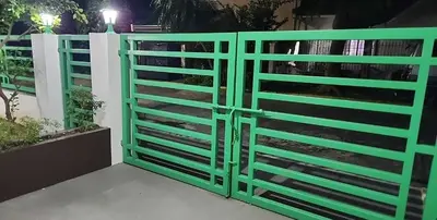 a green gate in front of a white fence at Short Stay BF Resort in Manila