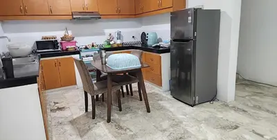 a kitchen with a table and a refrigerator at Short Stay BF Resort in Manila