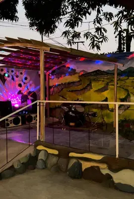 a stage with a rock wall with a musical performance at 143 Private Resort in Trece Martires