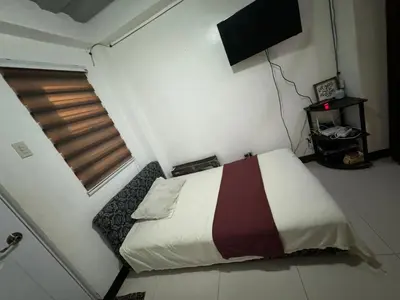a small bedroom with a bed and a window at 143 Private Resort in Trece Martires