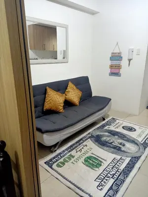 a blue couch in a living room with a rug at Staycation in Shore Residence's in Manila