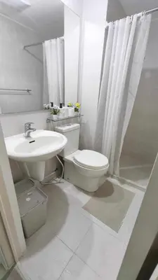 a white bathroom with a toilet and a sink at Casa Elisha Azure Urban Resort Staycation in Manila
