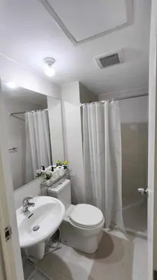 a white bathroom with a toilet and a sink at Casa Elisha Azure Urban Resort Staycation in Manila
