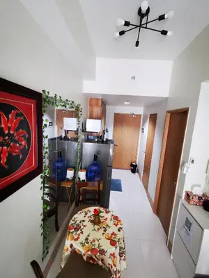 a living room with a table and a kitchen at Aldo mall of Asia shore 3 residence in Manila