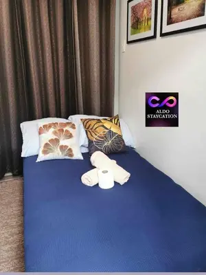 a bed with two towels and pillows on it at Aldo mall of Asia shore 3 residence in Manila
