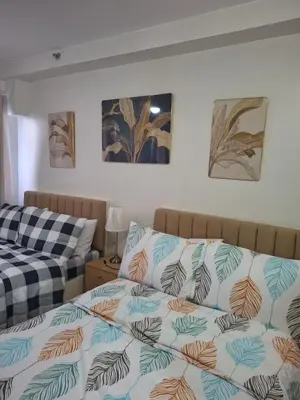 a bedroom with two beds and paintings on the wall at Simplicity in Manila