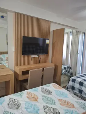 a hotel room with a bed and a flat screen tv at Simplicity in Manila