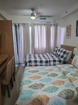 a bedroom with two beds and a desk at Simplicity in Manila