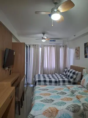 a hotel room with two beds and a television at Simplicity in Manila