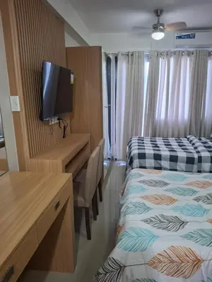 a hotel room with two beds and a desk and a tv at Simplicity in Manila