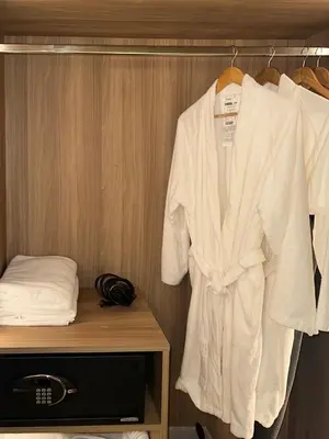 a robe hanging on a rack in a hotel room at Novotel Suites Celestia at Hotel Residences Manila in Manila