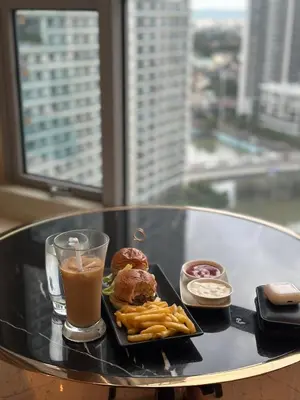 a tray with donuts and fries and a drink on a table at Novotel Suites Celestia at Hotel Residences Manila in Manila