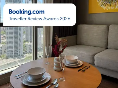 a table with plates and glasses on it in a living room at Novotel Suites Celestia at Hotel Residences Manila in Manila