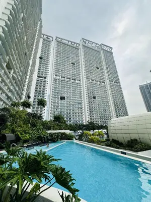 a large building with a swimming pool in front of it at Novotel Suites Celestia at Hotel Residences Manila in Manila