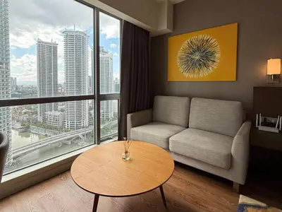 a living room with a couch and a table at Novotel Suites Celestia at Hotel Residences Manila in Manila