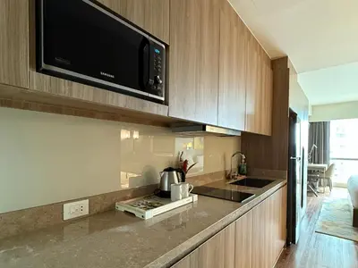 a kitchen with a counter top with a microwave at Novotel Suites Celestia at Hotel Residences Manila in Manila