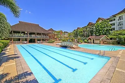 a large swimming pool in front of a house at Staycation with Mickey & Minnie One Oasis Pasig in Manila
