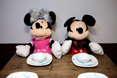 two stuffed animals sitting on top of a wooden table at Staycation with Mickey & Minnie One Oasis Pasig in Manila