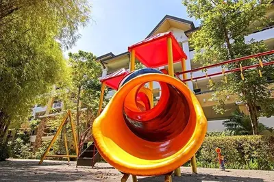 a playground with an orange slide in front of a building at Staycation with Mickey & Minnie One Oasis Pasig in Manila