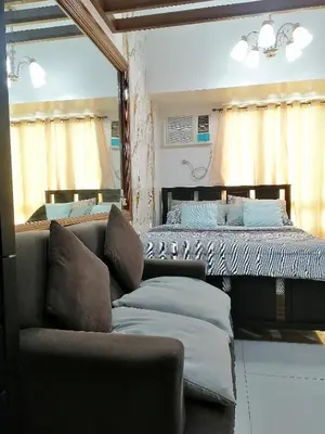 a living room with a couch and a bed at Studio Unit at The Beacon Makati in Manila