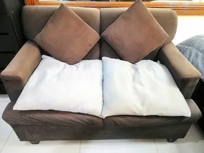 two pillows sitting on top of a brown couch at Studio Unit at The Beacon Makati in Manila
