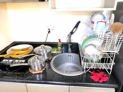 a kitchen sink with dishes and a dish drying rack at Studio Unit at The Beacon Makati in Manila