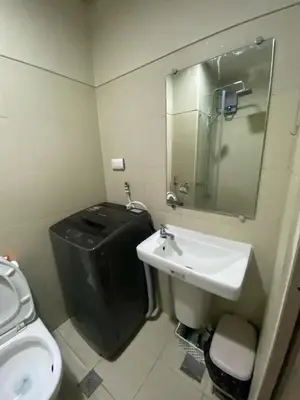 a bathroom with a sink and a toilet and a mirror at The Skycabin at S Residences in Manila