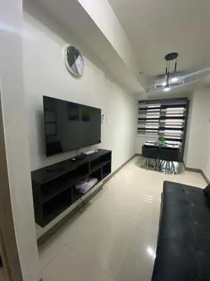 a living room with a flat screen tv on a wall at The Skycabin at S Residences in Manila