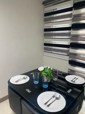 a dining table with plates and cutlery on it at The Skycabin at S Residences in Manila