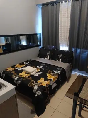 a bedroom with a bed with a black blanket at Berto's High Speed Wifi in Manila