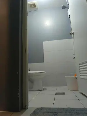 a bathroom with a toilet and a door open at Berto's High Speed Wifi in Manila