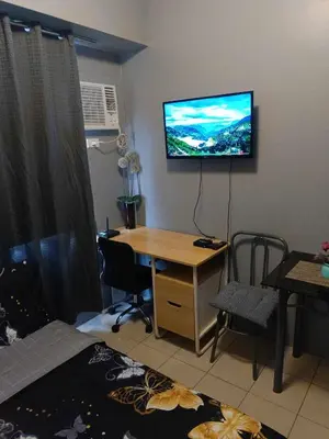 a room with a desk and a television on the wall at Berto's High Speed Wifi in Manila