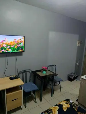 a living room with a table and a flat screen tv at Berto's High Speed Wifi in Manila