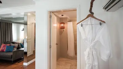 a white robe hanging on a door in a room at MIRANAMIN NEST Elegant Home, Indoor Plunge Pool, Pet-Friendly, with Rooftop, Kitchens, Self-Service Breakfast - Ideal for Reunions, Team Building, Intimate Gatherings in Manila