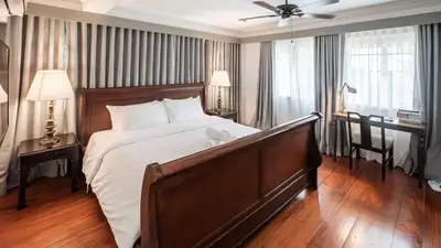 a large bedroom with a large bed and a desk at MIRANAMIN NEST Elegant Home, Indoor Plunge Pool, Pet-Friendly, with Rooftop, Kitchens, Self-Service Breakfast - Ideal for Reunions, Team Building, Intimate Gatherings in Manila
