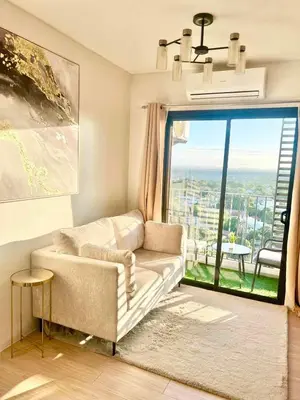 a living room with a couch and a large window at NEW! The Hive Residences - 1BR with Balcony & FREE Parking at Casa Arbo in Taytay