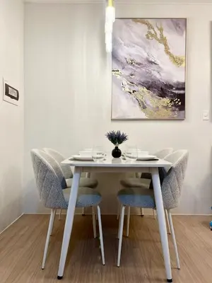 a dining room table with chairs and a painting at NEW! The Hive Residences - 1BR with Balcony & FREE Parking at Casa Arbo in Taytay