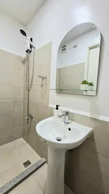 a bathroom with a sink and a shower with a mirror at NEW! The Hive Residences - 1BR with Balcony & FREE Parking at Casa Arbo in Taytay