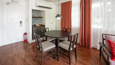 a dining room with a table and chairs at MiraNamin Nest BANABA - Garden View Suite in Historic Home - Bathtub, Luxury Indoor Plunge Pool, Guest Kitchen, Self-Service Breakfast, Rooftop, Pet-Friendly in Manila