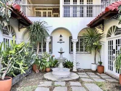 a fountain in the courtyard of a building with plants at MiraNamin Nest CALACHUCHI - Cozy Room in Historic Home - Indoor Plunge Pool, Petite Desk, Garden View with Balcony, Self-Service Breakfast, Guest Kitchen, Rooftop, Pet-Friendly in Manila