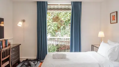a bedroom with a bed and a large window at MiraNamin Nest KAMANTIGI - Two Bed Suite in Historic Home with Luxury Indoor Plunge Pool, Garden Access, Self-Service Breakfast, Guest Kitchen, Pet-Friendly in Manila