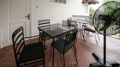 a table and chairs sitting on a patio at MiraNamin Nest LANTANA - Luxury Suite in Unique Historic Home with Garden Access, Indoor Plunge Pool, Self-Service Breakfast, Rooftop, Bathtub, Private Kitchen in Manila