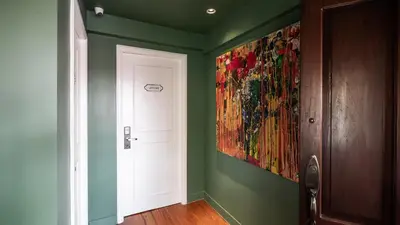 a hallway with a painting on the wall next to a door at MiraNamin Nest LIRYO and LANTANA - Luxury Residence in Unique Historic Home - Indoor Plunge Pool, Self-Service Breakfast, Garden View, Rooftop, Private Kitchen in Manila