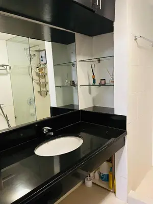 a bathroom with a sink and a mirror at The Mindful Home - 2BR Cozy Condo near NAIA in Manila