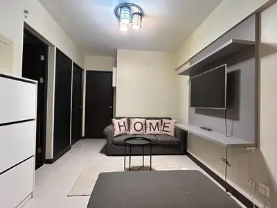 a living room with a couch and a television at The Mindful Home - 2BR Cozy Condo near NAIA in Manila